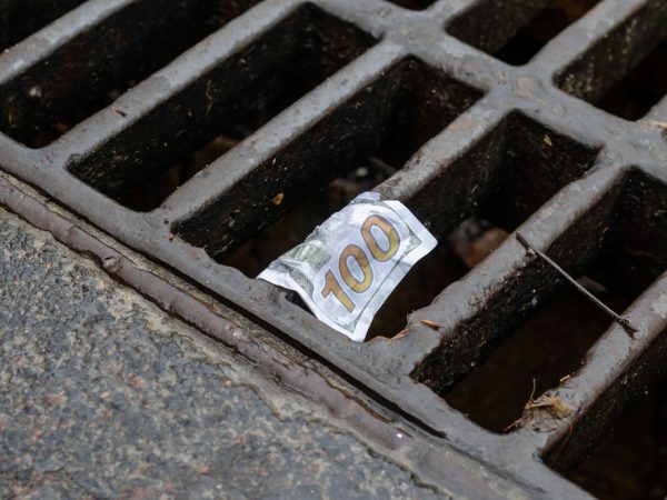 A close up of a one hundred dollar bill on the ground