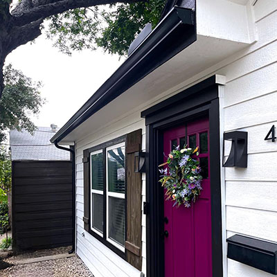 A purple door and wreath on the front of a house.