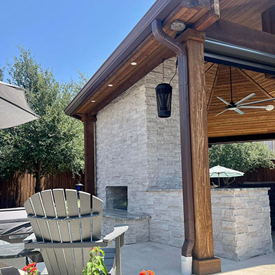 A patio with an outdoor fireplace and a large covered area.