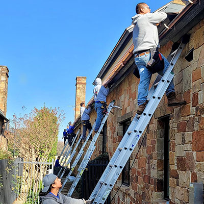 A group of men on ladders working on the side of a building.