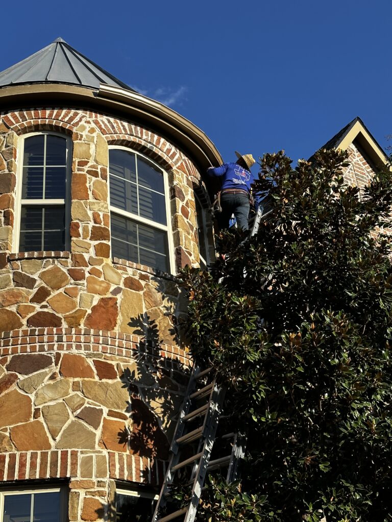 A man on a ladder in front of a building.