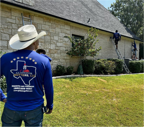 A man in a cowboy hat and blue shirt is looking at the house.
