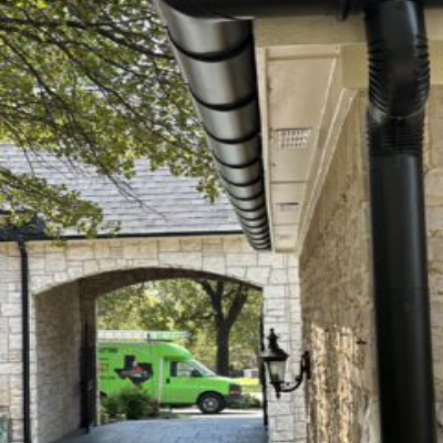 A green van is parked in the driveway of a house.